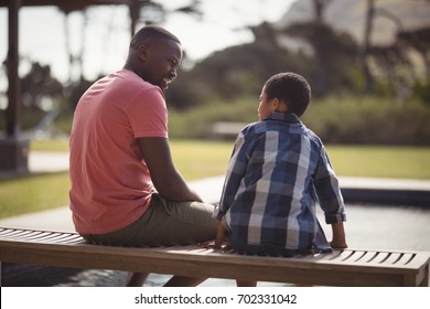 Smiling Father Talking To Son Near Pool Side