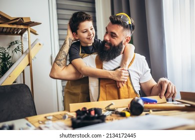 Smiling Father Is Teaching His Son Of Working With Wood At Home. 