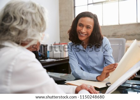 Smiling female analyst in consultation with senior woman