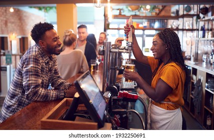 Smiling Female Bartender Behind Counter Serving Female Customer With Beer - Powered by Shutterstock