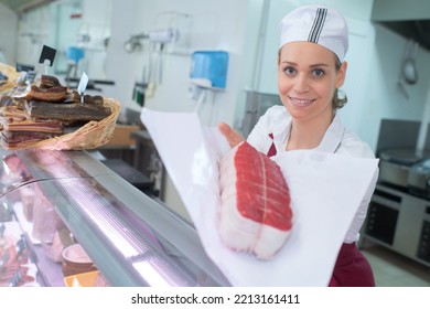 Smiling Female Butcher Holding Meat