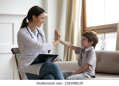 Smiling Female Caucasian Doctor Or Nurse Give High Five To Little Boy Patient At Consultation. Happy Millennial Woman Pediatrician Have Fun Greeting With Small Child In Hospital. Good Service Concept.