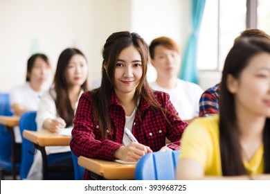 Smiling Female College Student Sitting  With Classmates