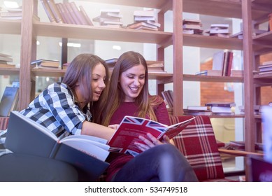 Smiling female college students studying in library