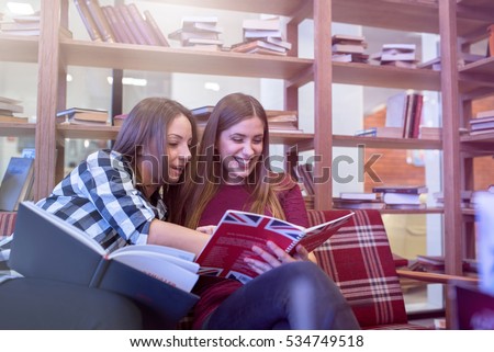 Smiling female college students studying in library