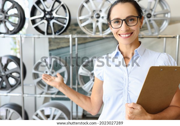 Smiling\
female consultant recommends car rims\
closeup