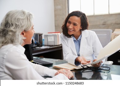 Smiling female doctor in consultation with senior patient
