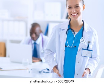 A smiling female doctor with a folder in uniform indoors - Shutterstock ID 503728849