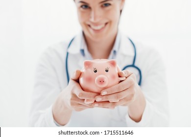 Smiling Female Doctor Holding A Piggy Bank: Health Insurance And Medical Expenses Concept