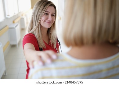 Smiling Female Doctor Keeps Hand On Patient Shoulder