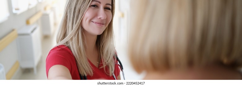 Smiling Female Doctor Keeps Hand On Patient Shoulder