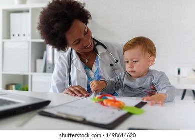 Smiling female doctor pediatrician with baby patient