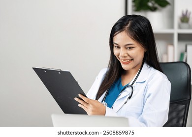 Smiling Female Doctor Reviewing Patient Records in Modern Medical Office - Powered by Shutterstock