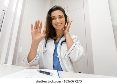 Smiling Female Doctor Wear Headset Make Online Telemedicine Video Call Consult Patient. Caucasian Woman Therapist Talking To Camera In Remote Videoconference Chat. Webcam View, Face Headshot