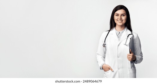 A smiling female doctor, wearing a white coat and stethoscope, stands against a white background, holding a clipboard in one hand. - Powered by Shutterstock