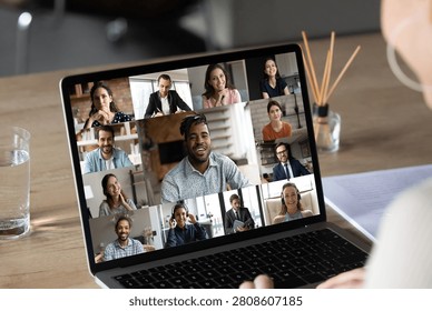 Smiling female employee using computer software application, holding video conference online call with multiracial colleagues and african american team leader, distant job business communication.