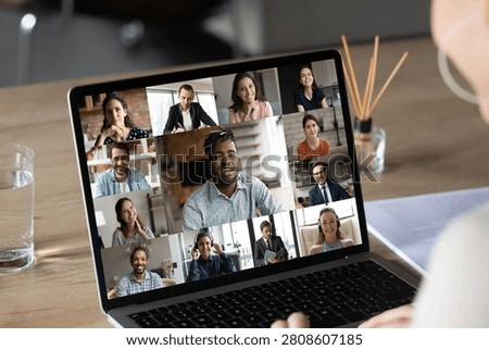 Smiling female employee using computer software application, holding video conference online call with multiracial colleagues and african american team leader, distant job business communication.