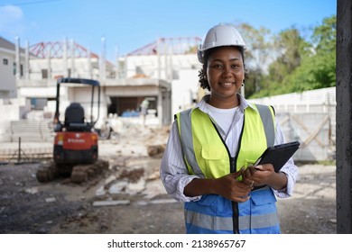 
Smiling Female Engineer, Wearing A Hard Hat, Vest, Holding A Tablet.cute Woman With Black Skin.Working On Construction Sites, Houses And Buildings.Workers Are Smart.use Of Technology In Industry