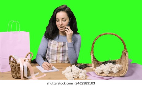 Smiling female florist taking order by the mobile phone on the chroma key - Powered by Shutterstock