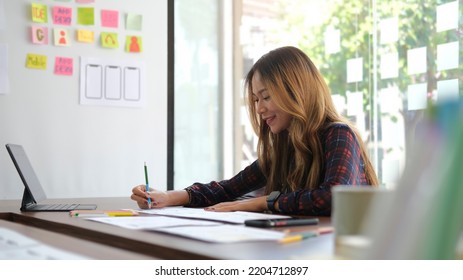 Smiling Female Graphic Designer Working With New Startup Project In Modern Office.	