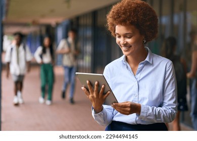 Smiling Female High School Or Secondary School Teacher With Digital Tablet Outdoors At School - Powered by Shutterstock