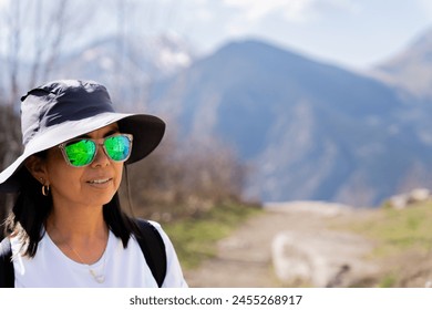Smiling female hiker enjoying the beautiful views from the top of the mountain on a beautiful spring morning in the Catalan Pyrenees