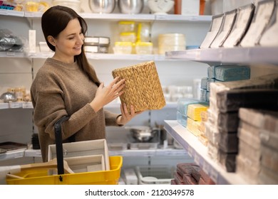Smiling female housewife choosing straw basket container for interior decor comfortable space organizing. Woman buying box storage pack organize eco friendly minimalist Mari Kondo placing metrod