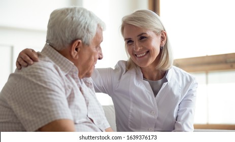 Smiling Female Nurse Or Doctor Hug Show Care And Support To Sick Senior Male Patient, Positive Middle-aged Woman Medical Worker Feel Supportive Comfort Mature Man, Elderly Healthcare Concept