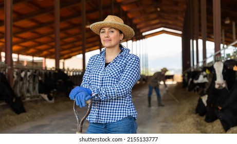 Smiling female proffesional farmer standing near cows at farm - Shutterstock ID 2155133777