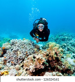 Smiling Female Scuba Diver Underwater On A Coral Reef