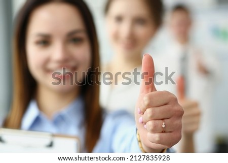Smiling female showing thumbs up and confirm success on camera