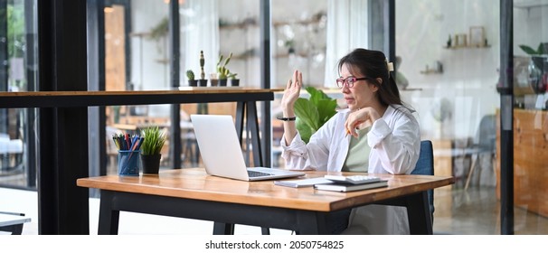 Smiling Female Small Business Entrepreneur Having Video Conference On Laptop Computer.