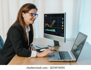 Smiling Female Trader Working On Laptop