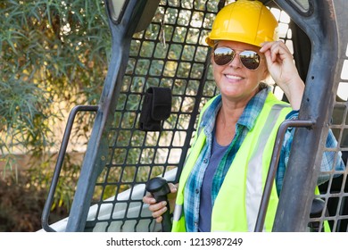 Smiling Female Worker Using Small Bulldozer At Constrcution Site