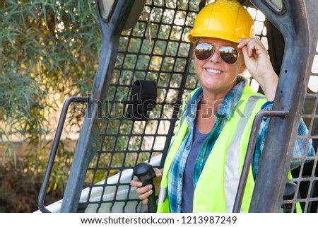 Smiling Female Worker Using Small Bulldozer At Constrcution Site