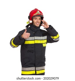 Smiling Fireman Using Cell Phone, Showing Thumb Up And Looking At Camera. Waist Up Studio Shot Isolated On White.