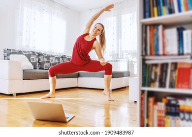 Smiling Fit Yoga Instructor Standing In Goddess Yoga Posture And Having Online Class. Home Interior.