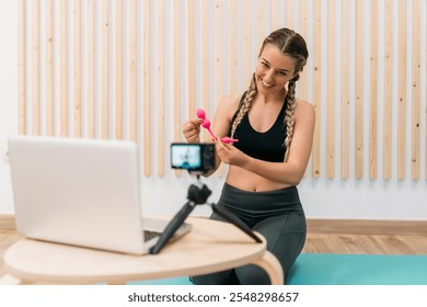 Smiling fitness blogger recording exercise video with vaginal weights - Powered by Shutterstock