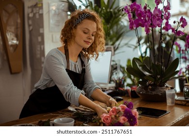 Smiling florist holding bouquet in flower shop - Powered by Shutterstock