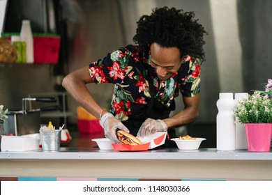 Smiling Food Vendor Hands Food To Waiting Customer