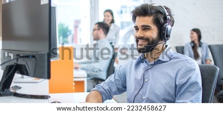 Smiling friendly helpline technical support operator in call centre.
