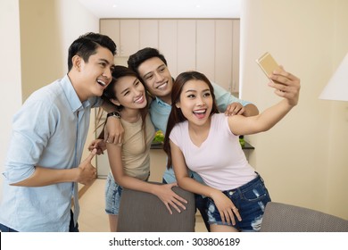 Smiling friends bonding together to take a perfect selfie