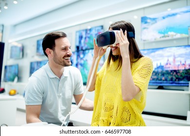 Smiling Friends Buying 3D Vr Glasses In Tech Store. Experiencing Virtual Gaming Adventure.