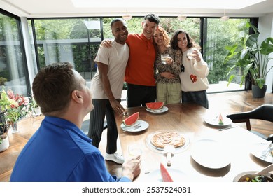 Smiling friends embracing at table - Powered by Shutterstock