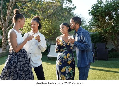 Smiling friends enjoying drinks in garden on sunny day - Powered by Shutterstock