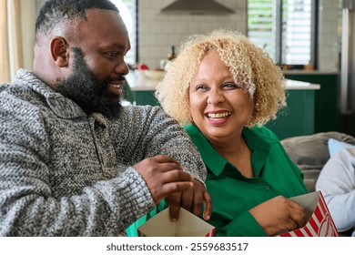 Smiling friends enjoying popcorn at home - Powered by Shutterstock