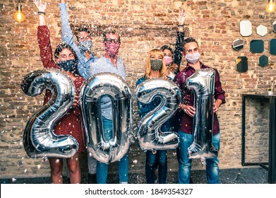 Smiling friends with face mask are celebrating new year's eve party in club in covid-19 time - Group of young people holding balloons looking at camera and smile wit eye all together throwing confetti - Powered by Shutterstock