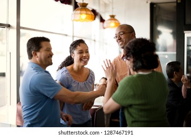 Smiling Friends Meeting For Coffee At A Local Diner.