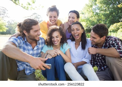 Smiling friends in the park taking selfie on a sunny day - Powered by Shutterstock