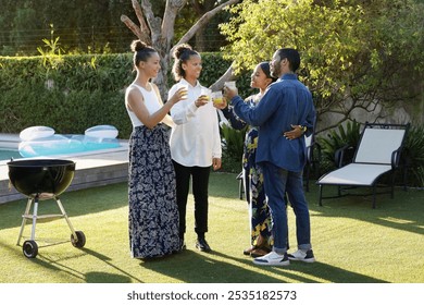 Smiling friends toasting with drinks in garden on sunny day - Powered by Shutterstock